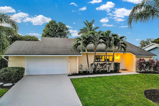 view of front of home with concrete driveway, a garage, a front lawn, and stucco siding