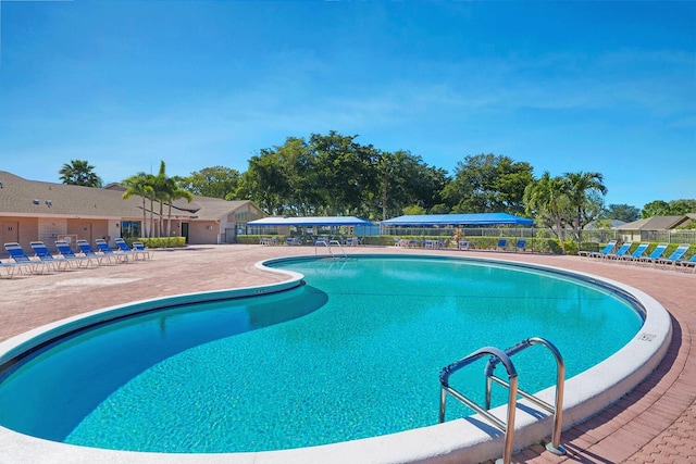pool with fence and a patio area
