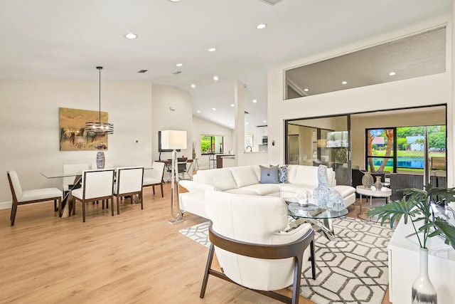 living room featuring high vaulted ceiling, recessed lighting, and light wood-style flooring