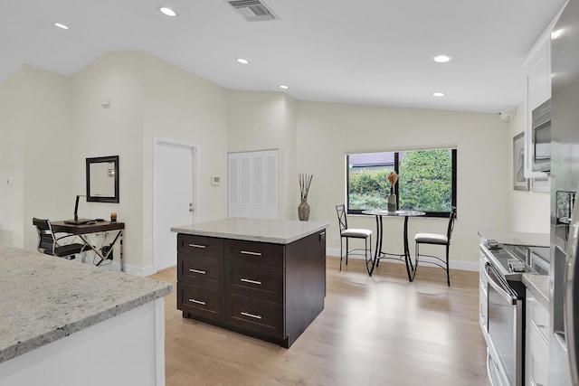 kitchen with visible vents, appliances with stainless steel finishes, dark brown cabinets, light wood finished floors, and lofted ceiling