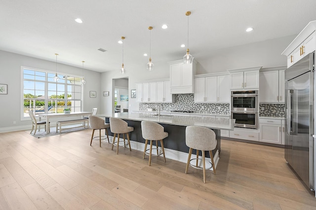 kitchen featuring recessed lighting, tasteful backsplash, light countertops, and appliances with stainless steel finishes