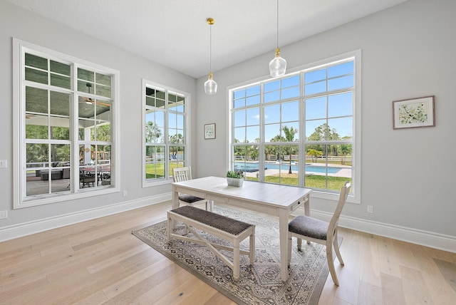 dining area with light wood finished floors and baseboards