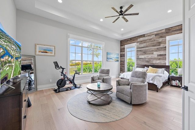 bedroom featuring light wood-style floors, wooden walls, baseboards, and recessed lighting