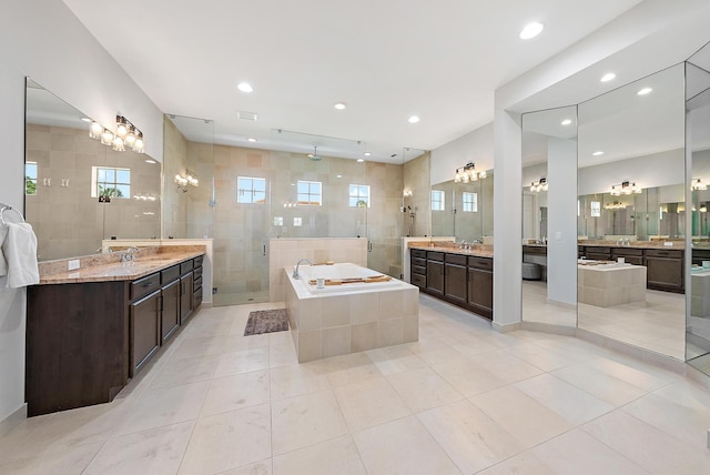 bathroom with two vanities, tile patterned flooring, a garden tub, a shower stall, and a sink