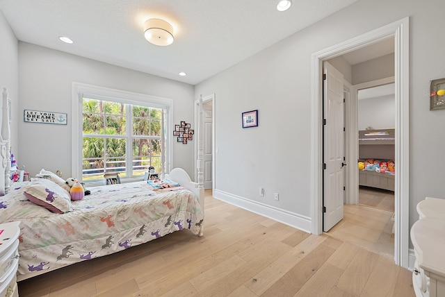 bedroom with light wood-type flooring, baseboards, and recessed lighting