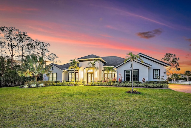 single story home with a yard and stucco siding