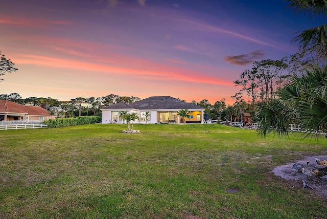 rear view of property with a yard and fence