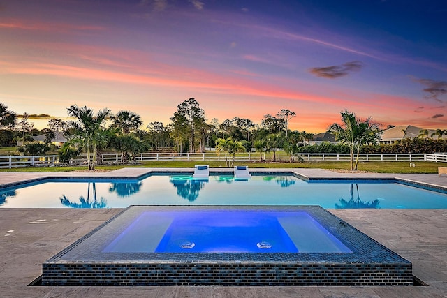 view of swimming pool featuring a yard, a fenced backyard, and a pool with connected hot tub