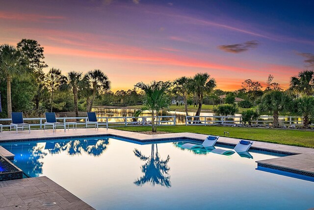 outdoor pool with a yard, a patio area, and fence