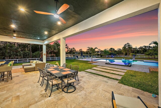view of patio / terrace with an outdoor pool, fence, outdoor dining area, and a ceiling fan