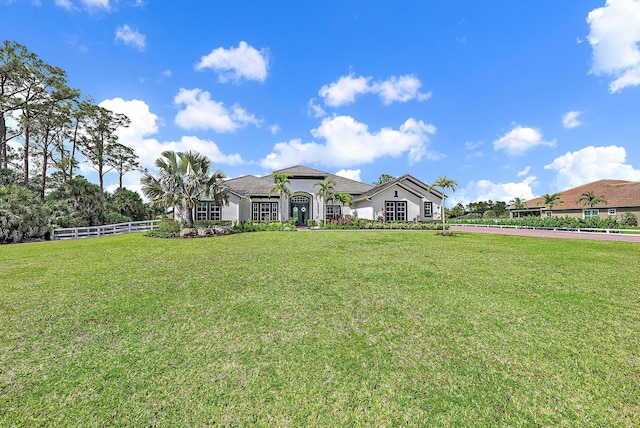 exterior space with a front yard, stucco siding, and fence