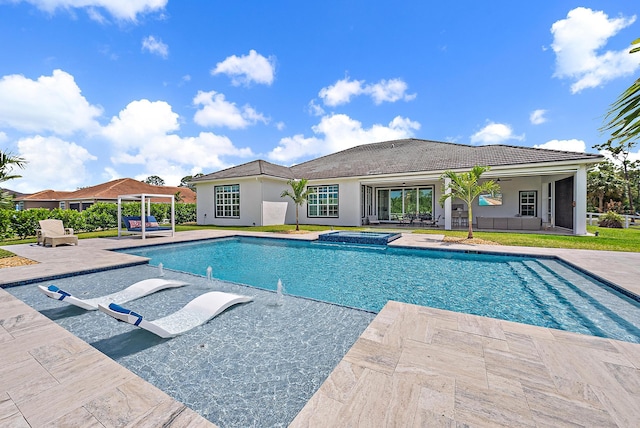 outdoor pool with a patio and a jacuzzi