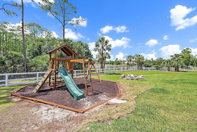 community play area with a water view, fence, and a lawn