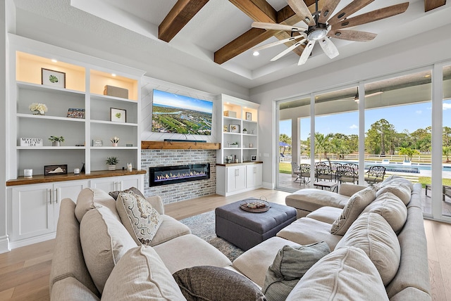 living room with a wealth of natural light, light wood finished floors, and a ceiling fan