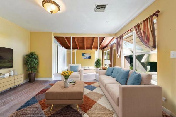 living area featuring visible vents, baseboards, and wood finished floors