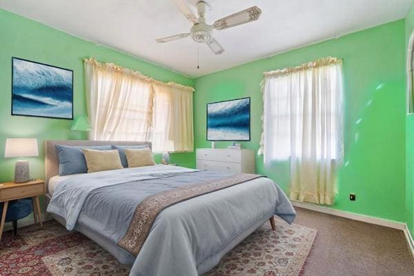carpeted bedroom with baseboards and a ceiling fan