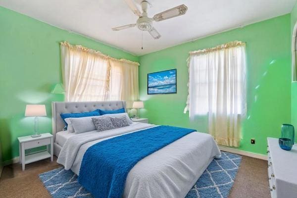 bedroom featuring carpet flooring, multiple windows, and baseboards