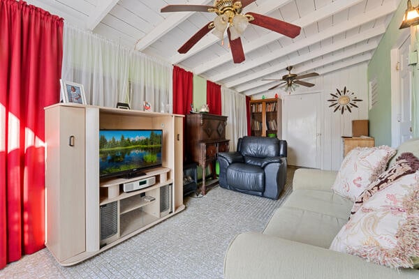 living area featuring wooden ceiling, ceiling fan, vaulted ceiling with beams, and carpet