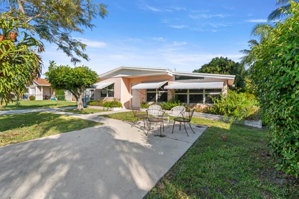 rear view of property featuring a patio and a lawn