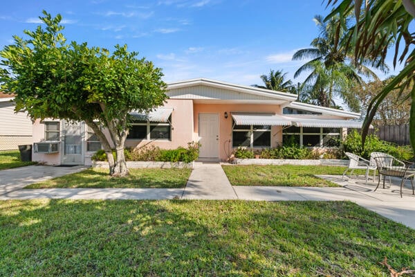 view of front of home with a patio area and a front yard