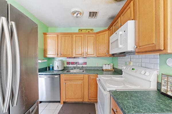 kitchen featuring a sink, visible vents, appliances with stainless steel finishes, and dark countertops
