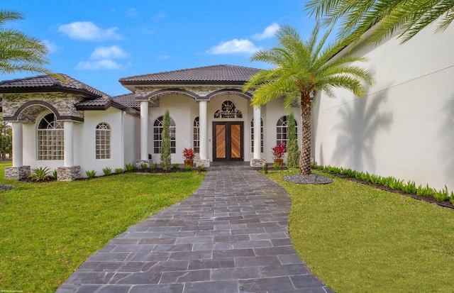 19361 W Sycamore Dr, The Acreage, FL 33470 - mediterranean / spanish home featuring a tiled roof, french doors, a front lawn, and stucco siding
