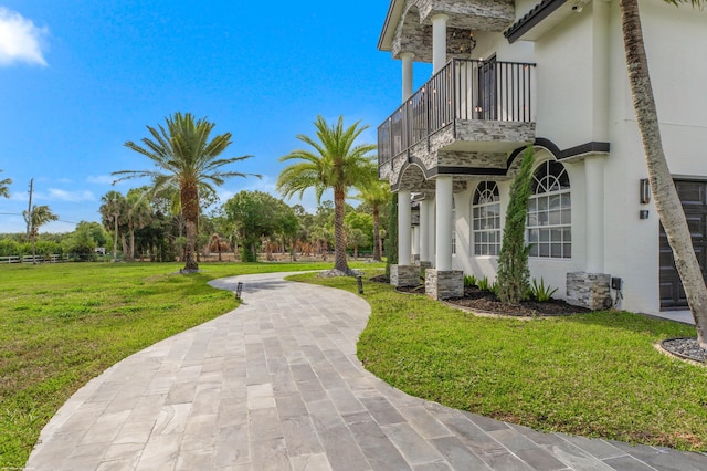 19361 W Sycamore Dr, The Acreage, FL 33470 - exterior space featuring a balcony, stucco siding, and a lawn