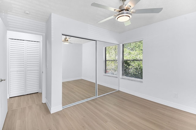 6551 SE Federal Hwy Unit 203, Stuart, FL 34997 - unfurnished bedroom featuring a closet, light wood-style flooring, baseboards, and ceiling fan