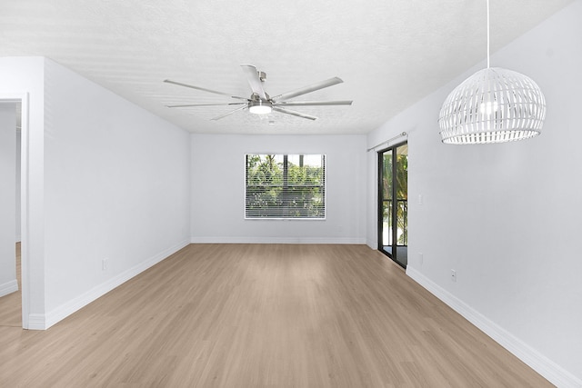 6551 SE Federal Hwy Unit 203, Stuart, FL 34997 - unfurnished living room with a textured ceiling, baseboards, light wood-type flooring, and ceiling fan with notable chandelier
