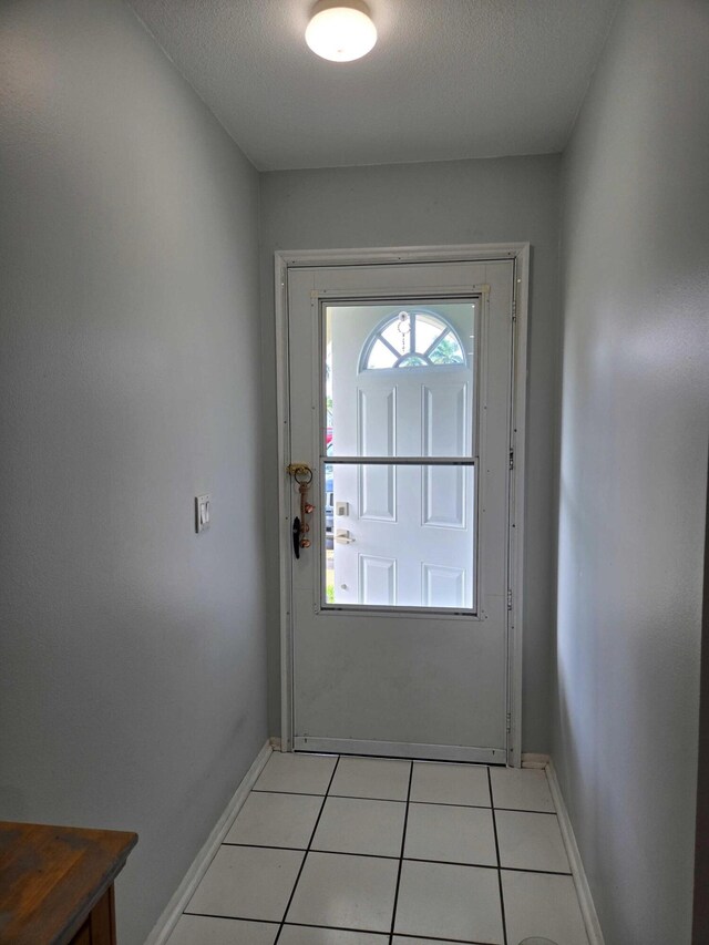 2970 E Ashley Dr E Unit B, West Palm Beach, FL 33415 - doorway with light tile patterned flooring and baseboards