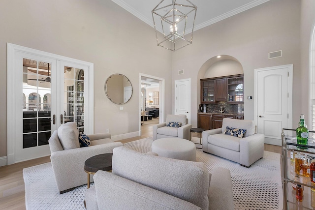 251 W Coconut Palm Rd, Boca Raton, FL 33432 - living area featuring light wood-style floors, a chandelier, a towering ceiling, visible vents, and ornamental molding