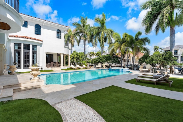 251 W Coconut Palm Rd, Boca Raton, FL 33432 - view of swimming pool featuring a patio, a lawn, and a pool with connected hot tub