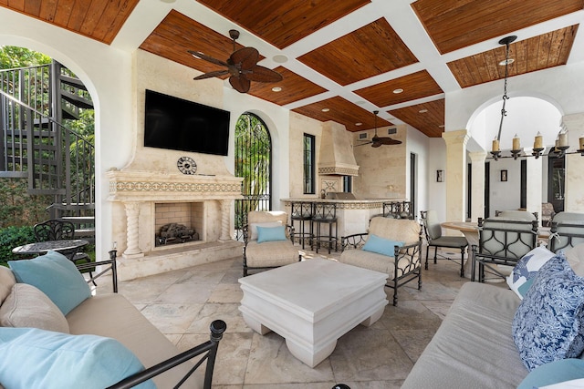 251 W Coconut Palm Rd, Boca Raton, FL 33432 - living room featuring decorative columns, wood ceiling, coffered ceiling, an outdoor fireplace, and ceiling fan with notable chandelier