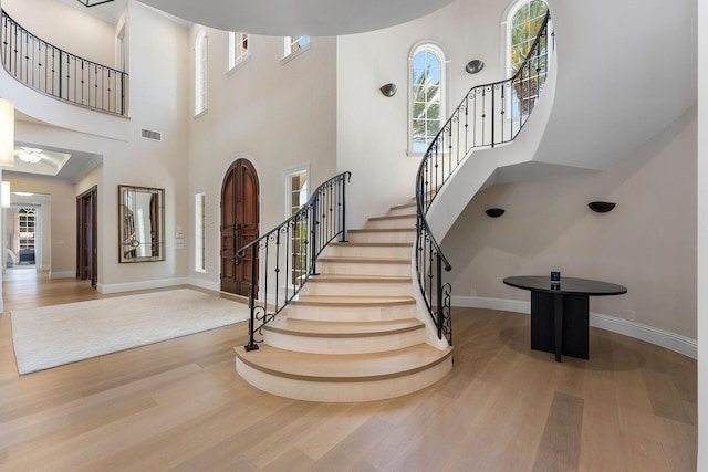 251 W Coconut Palm Rd, Boca Raton, FL 33432 - foyer with visible vents, stairs, a towering ceiling, wood finished floors, and baseboards