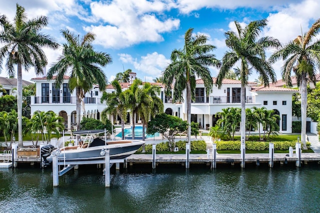 251 W Coconut Palm Rd, Boca Raton, FL 33432 - rear view of property with boat lift, a water view, stucco siding, and an outdoor pool