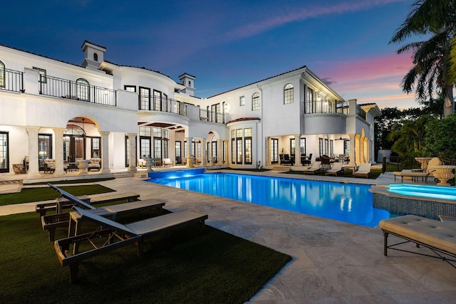 251 W Coconut Palm Rd, Boca Raton, FL 33432 - pool at dusk with french doors, a pool with connected hot tub, a patio area, and outdoor lounge area