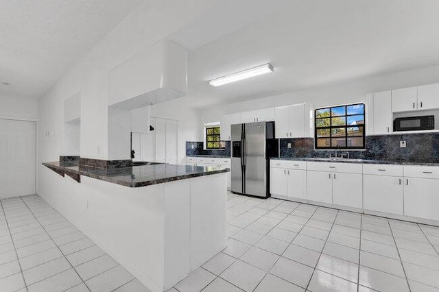 3682 W 2nd Ave, Hialeah, FL 33012 - kitchen featuring stainless steel refrigerator with ice dispenser, black microwave, backsplash, light tile patterned flooring, and white cabinets