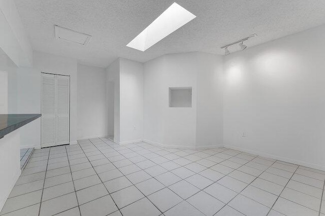 3682 W 2nd Ave, Hialeah, FL 33012 - unfurnished room featuring a textured ceiling, light tile patterned floors, and rail lighting