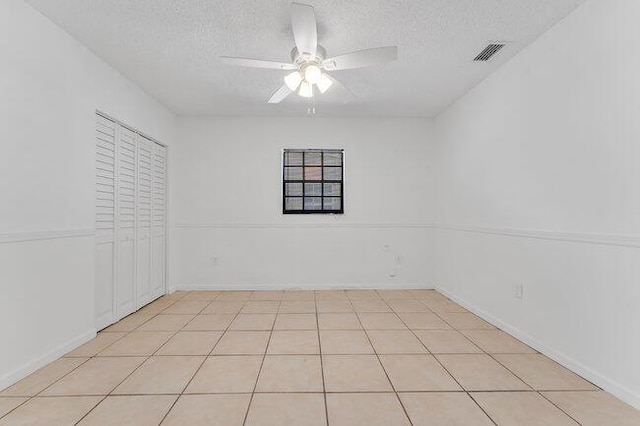 3682 W 2nd Ave, Hialeah, FL 33012 - unfurnished bedroom with a textured ceiling, a closet, ceiling fan, and light tile patterned floors