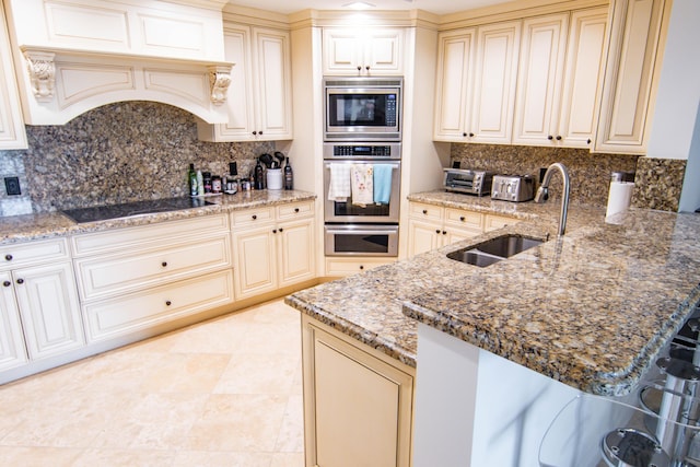 200 E Palmetto Park Rd Unit 503, Boca Raton, FL 33432 - kitchen with black electric stovetop, a sink, stainless steel microwave, and cream cabinets