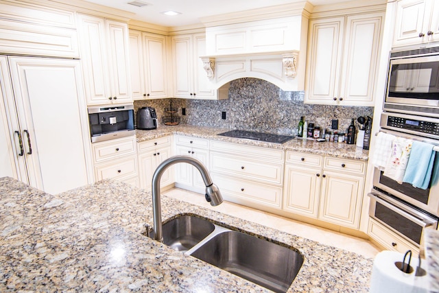 200 E Palmetto Park Rd Unit 503, Boca Raton, FL 33432 - kitchen featuring a sink, tasteful backsplash, a warming drawer, light stone counters, and appliances with stainless steel finishes