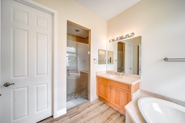 full bathroom featuring a shower stall, a bath, vanity, and baseboards