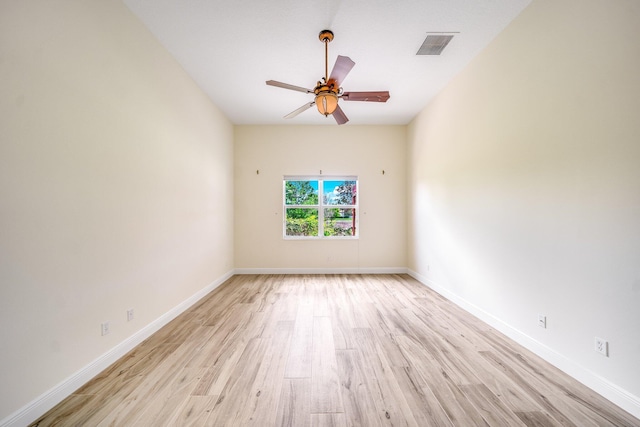 empty room with light wood finished floors, baseboards, ceiling fan, and visible vents