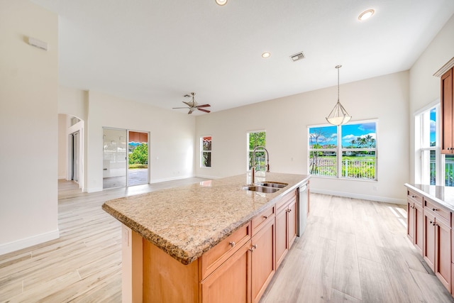 kitchen featuring light wood-style flooring, a wealth of natural light, a ceiling fan, and a sink