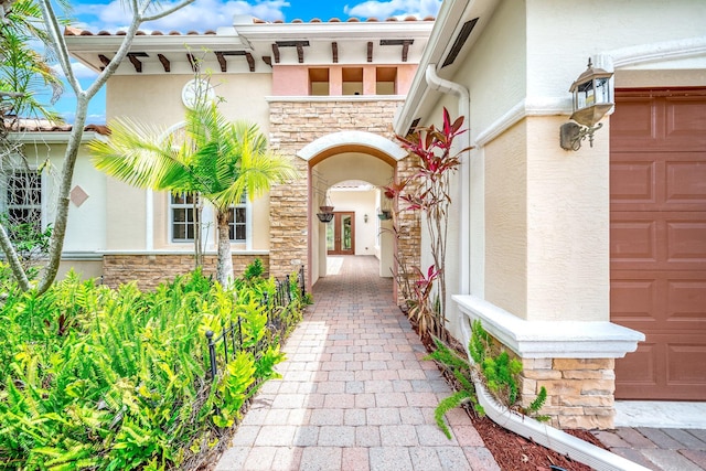 entrance to property featuring stone siding and stucco siding