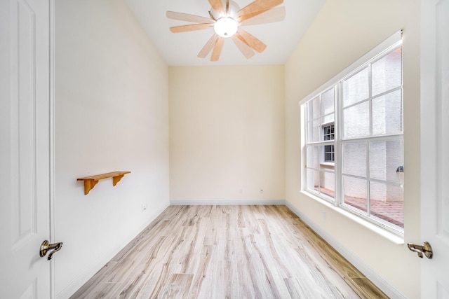 spare room featuring ceiling fan, baseboards, and light wood-type flooring