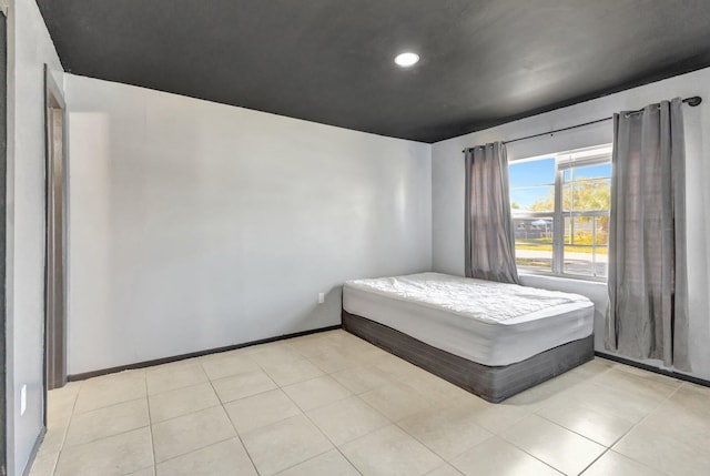 bedroom with light tile patterned floors and baseboards