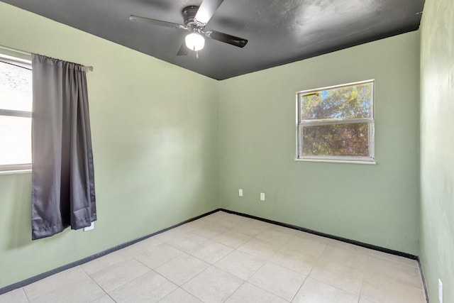 spare room featuring ceiling fan and baseboards