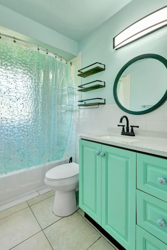 bathroom featuring shower / tub combo, vanity, tile patterned flooring, toilet, and tile walls