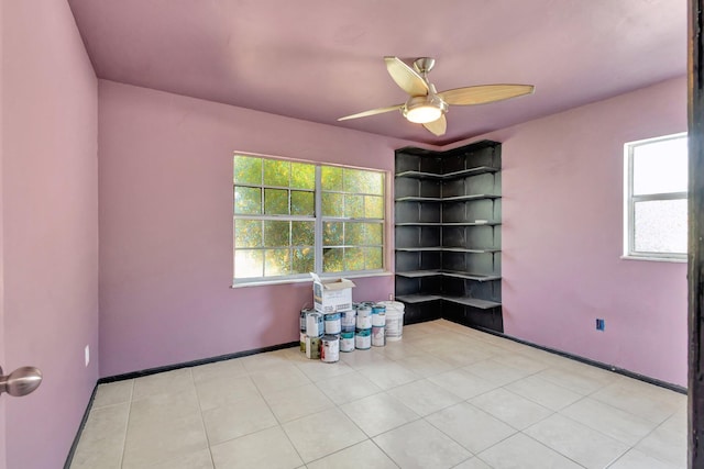 empty room featuring light tile patterned flooring, baseboards, and a ceiling fan